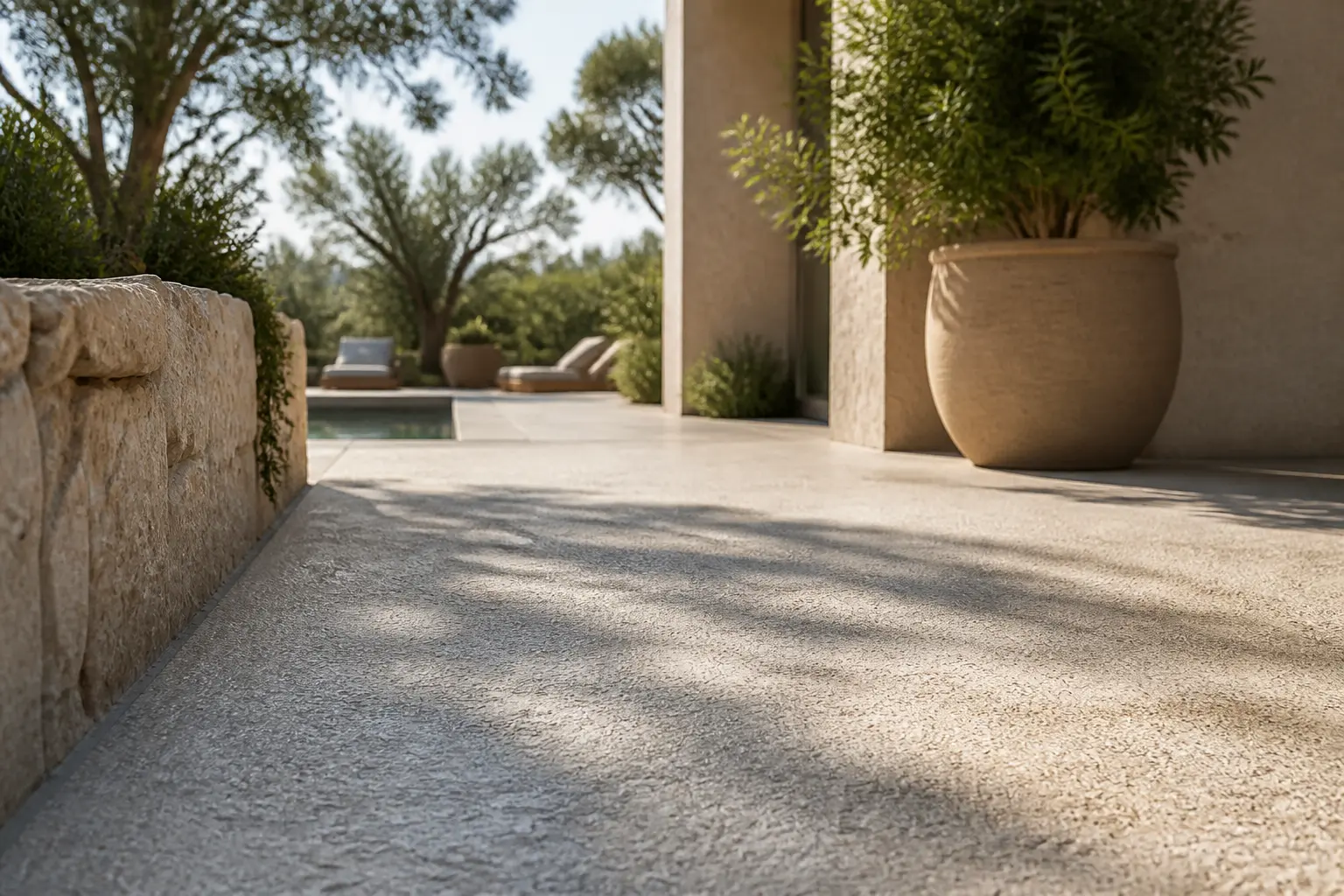 Terrasse en béton bouchardé texturé dans un jardin moderne, tons chauds et lumière naturelle, style premium