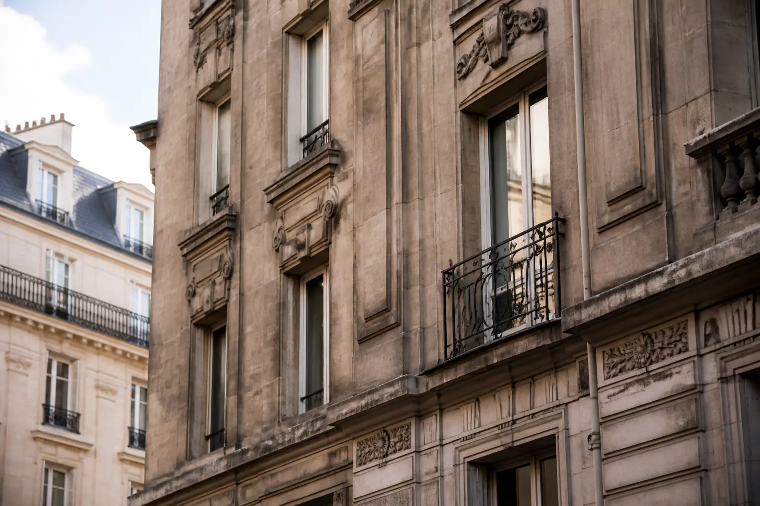 Nettoyage façade pierre reconstituée Paris : immeuble parisien en pierre reconstituée ternie par pollution et humidité