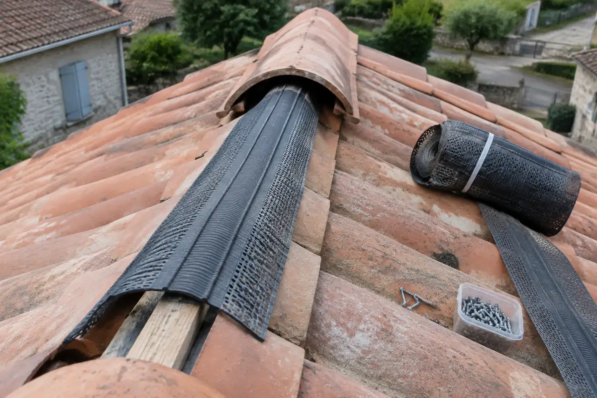 Closoir souple posé le long d'une ligne de faîtage, sous des tuiles faîtières non encore fixées